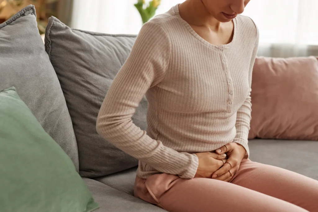 woman on couch with abdominal discomfort 2026 09 23 19 17 41 utc